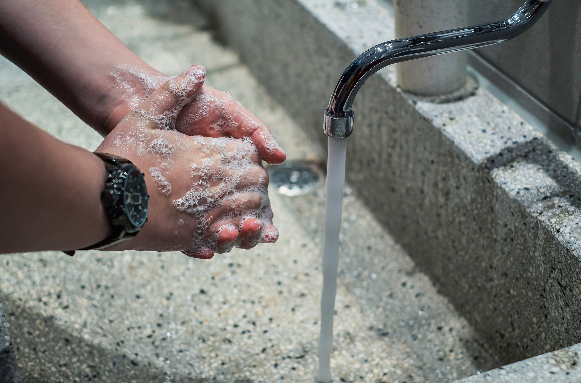 Worker washing hands for industrial hygiene